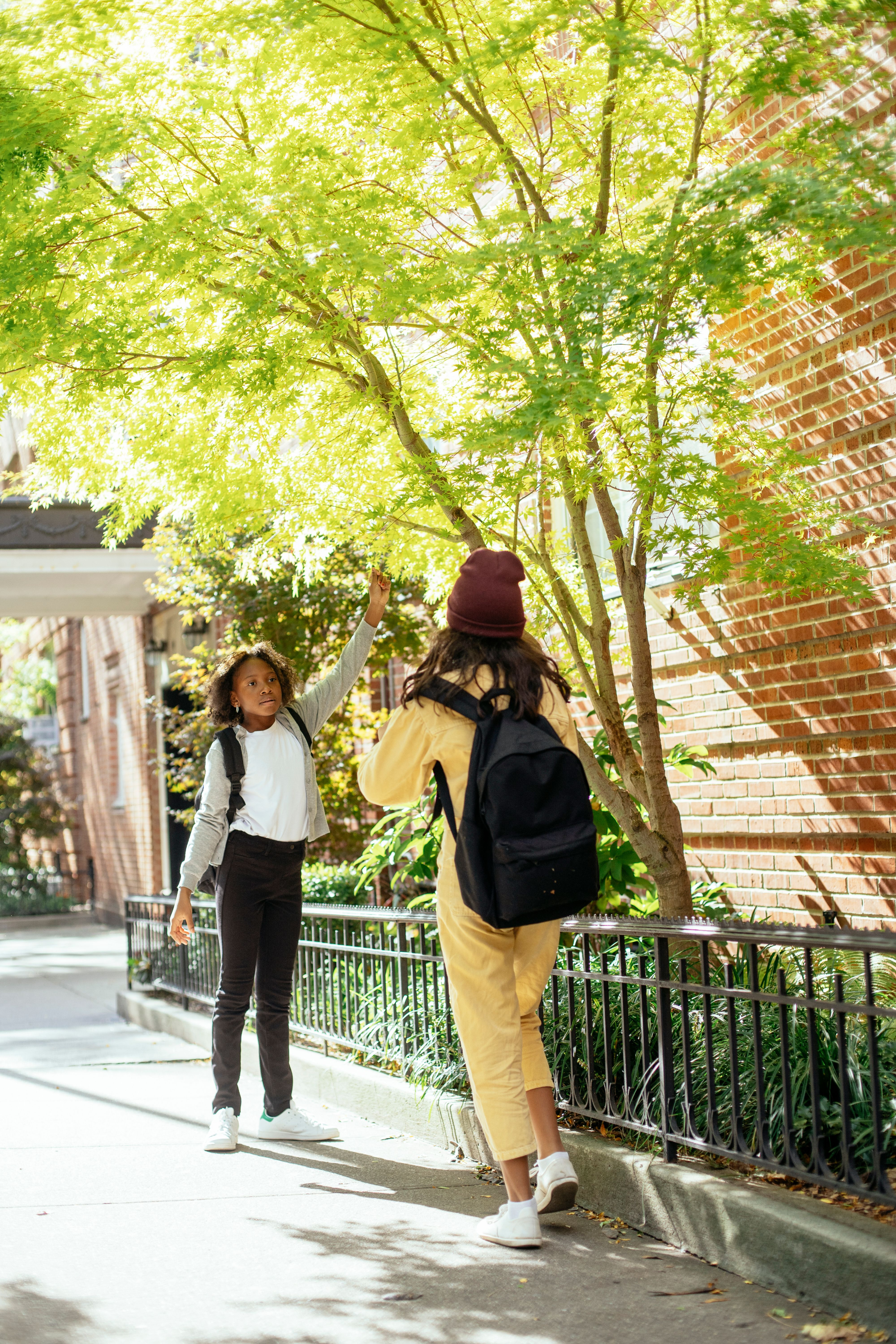 Two students with backpacks walking on school campus