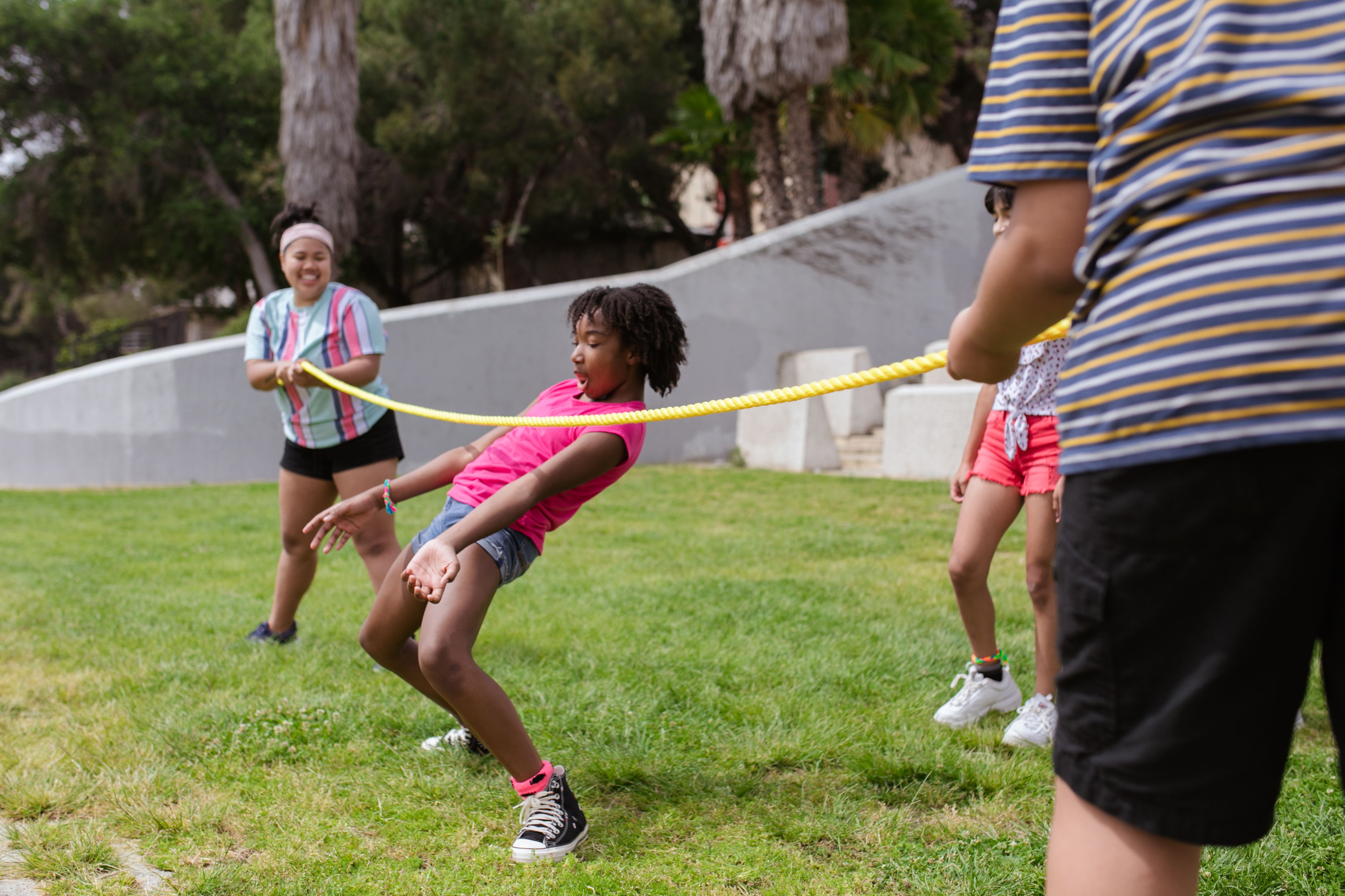 Kids playing limbo game outdoors at camp